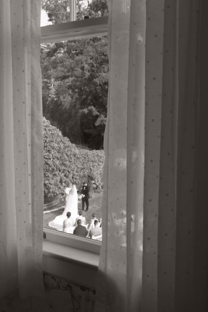 Bride and groom at the alter captured through the window.
