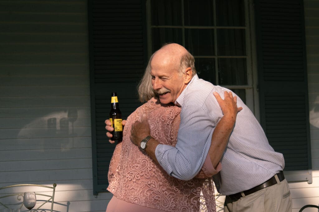 Father of the groom hugging a friend during cocktail hour.