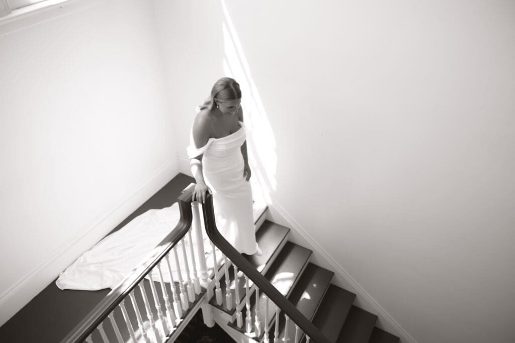 Bride walking down the stairs to her father for the first look.